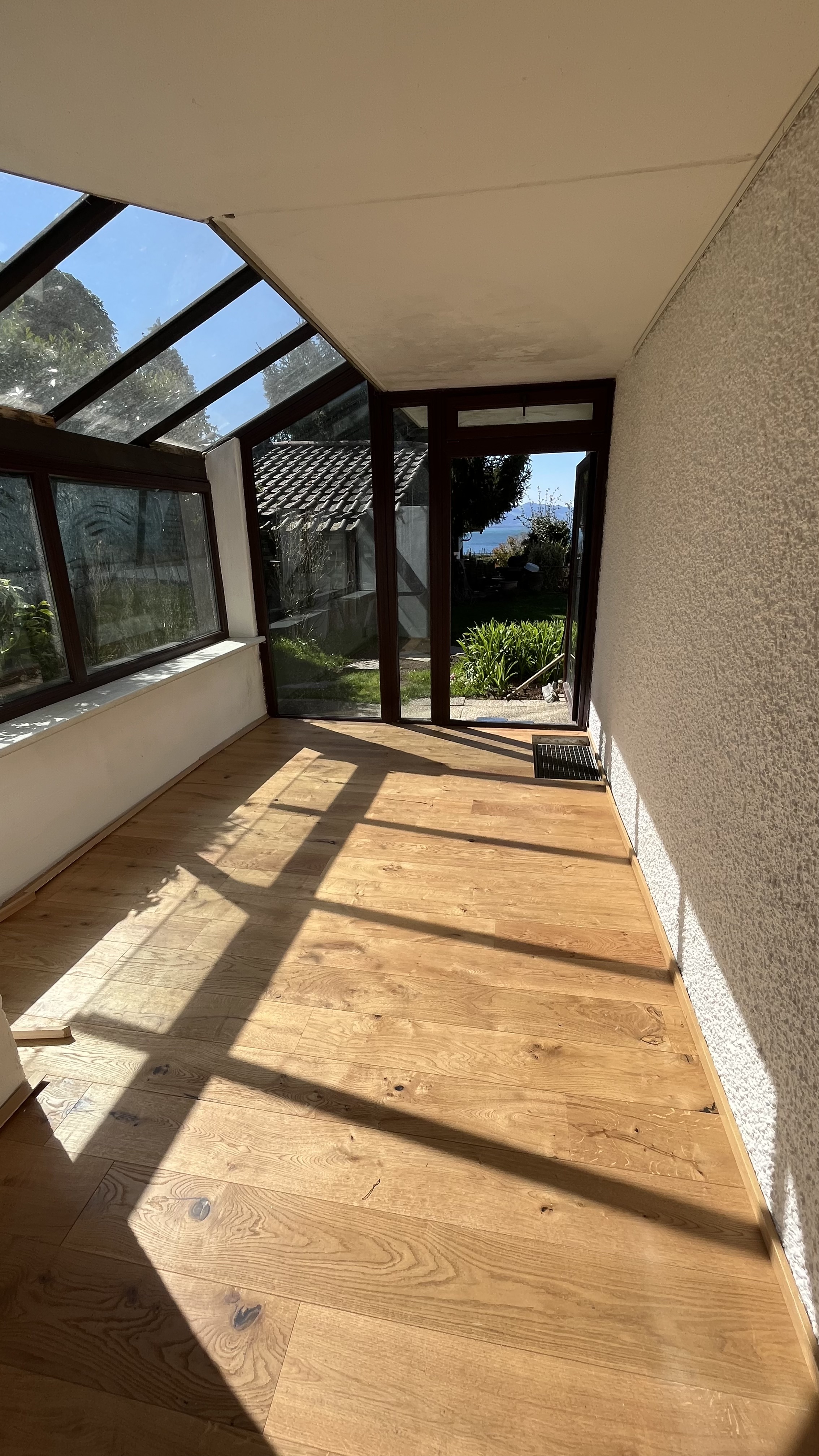 Wintergarten mit Holzboden und Zugang zum Garten